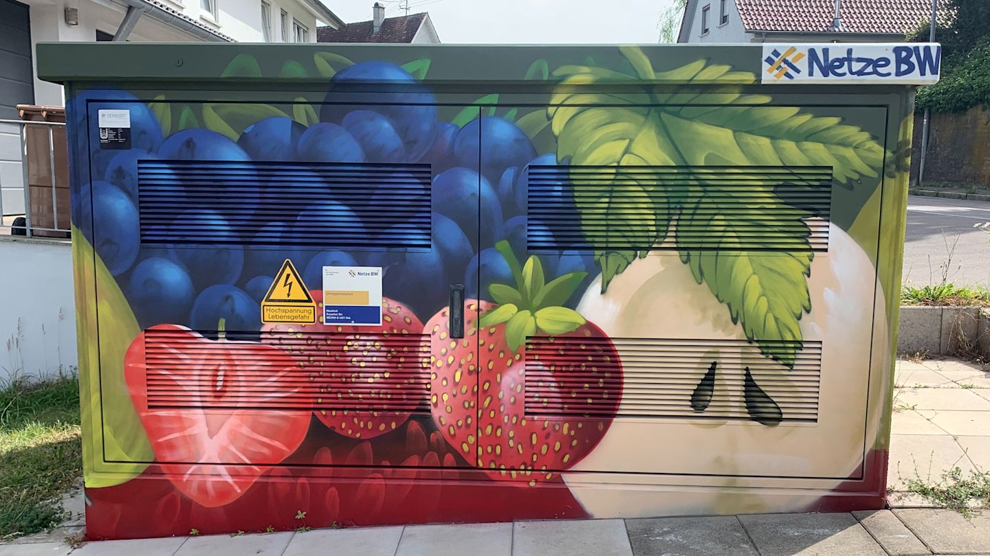 Trafostation mit Obst-Motiv: Erdbeeren, Heidelbeeren, halbierter Apfel.