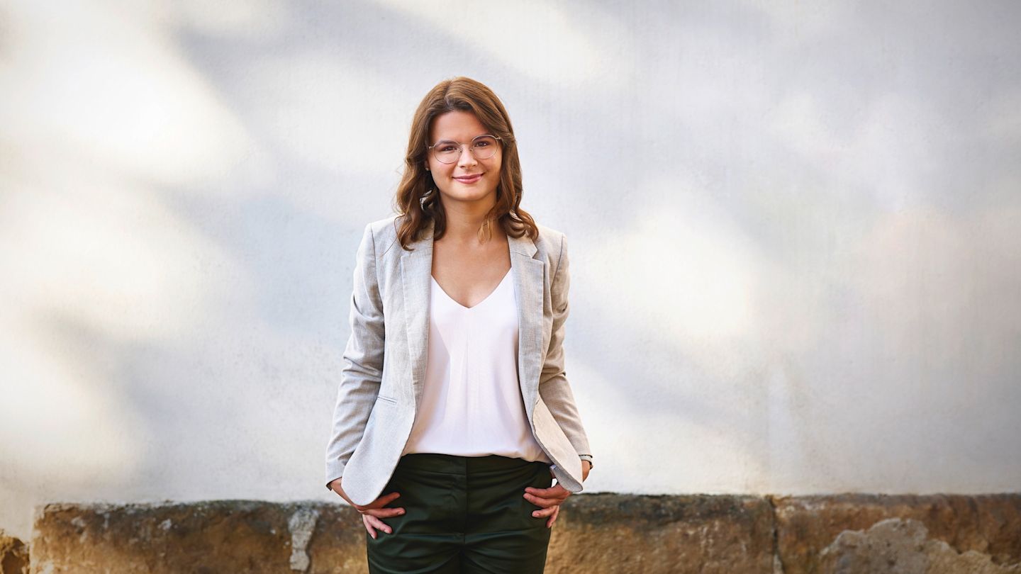 Lächelnde junge Frau im grauen Blazer.