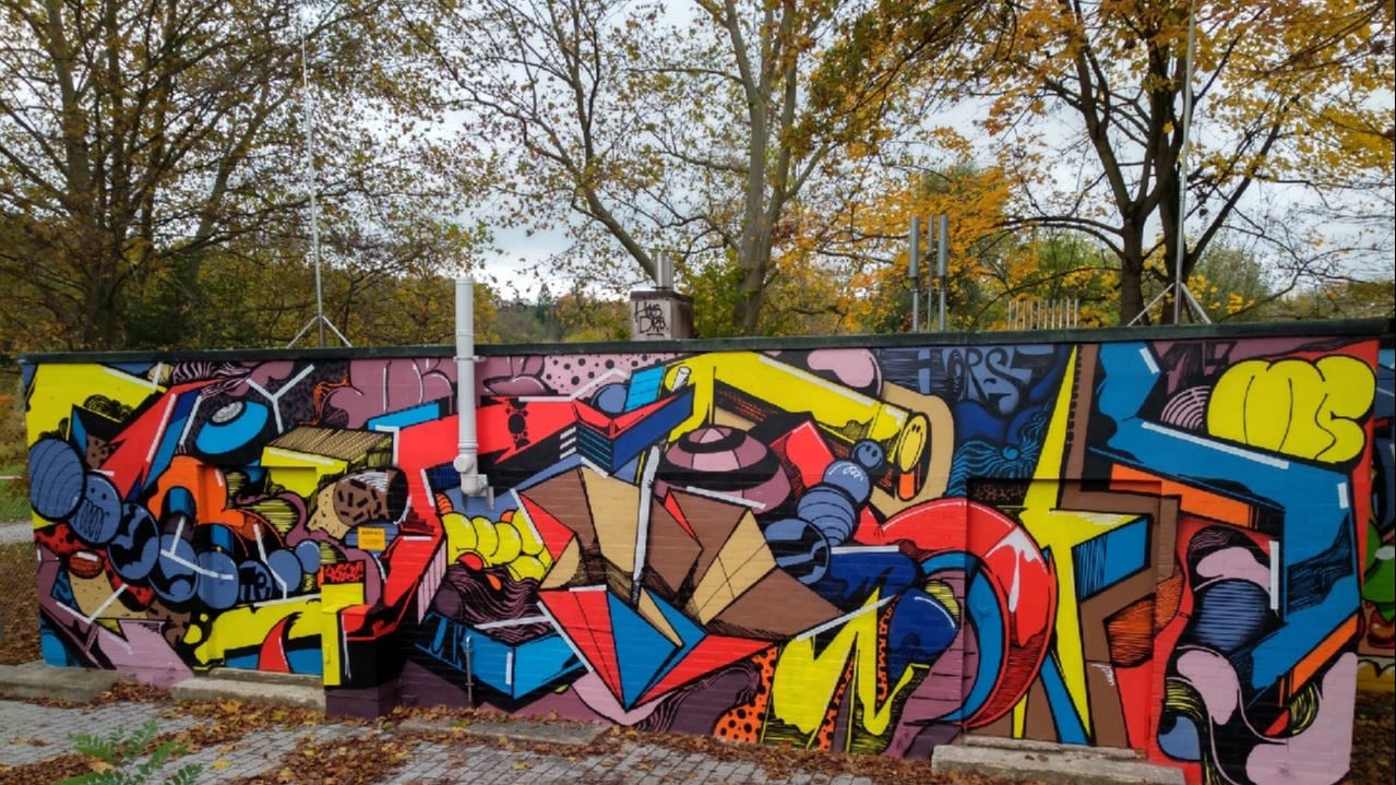 Buntes Graffiti an einer Mauer.