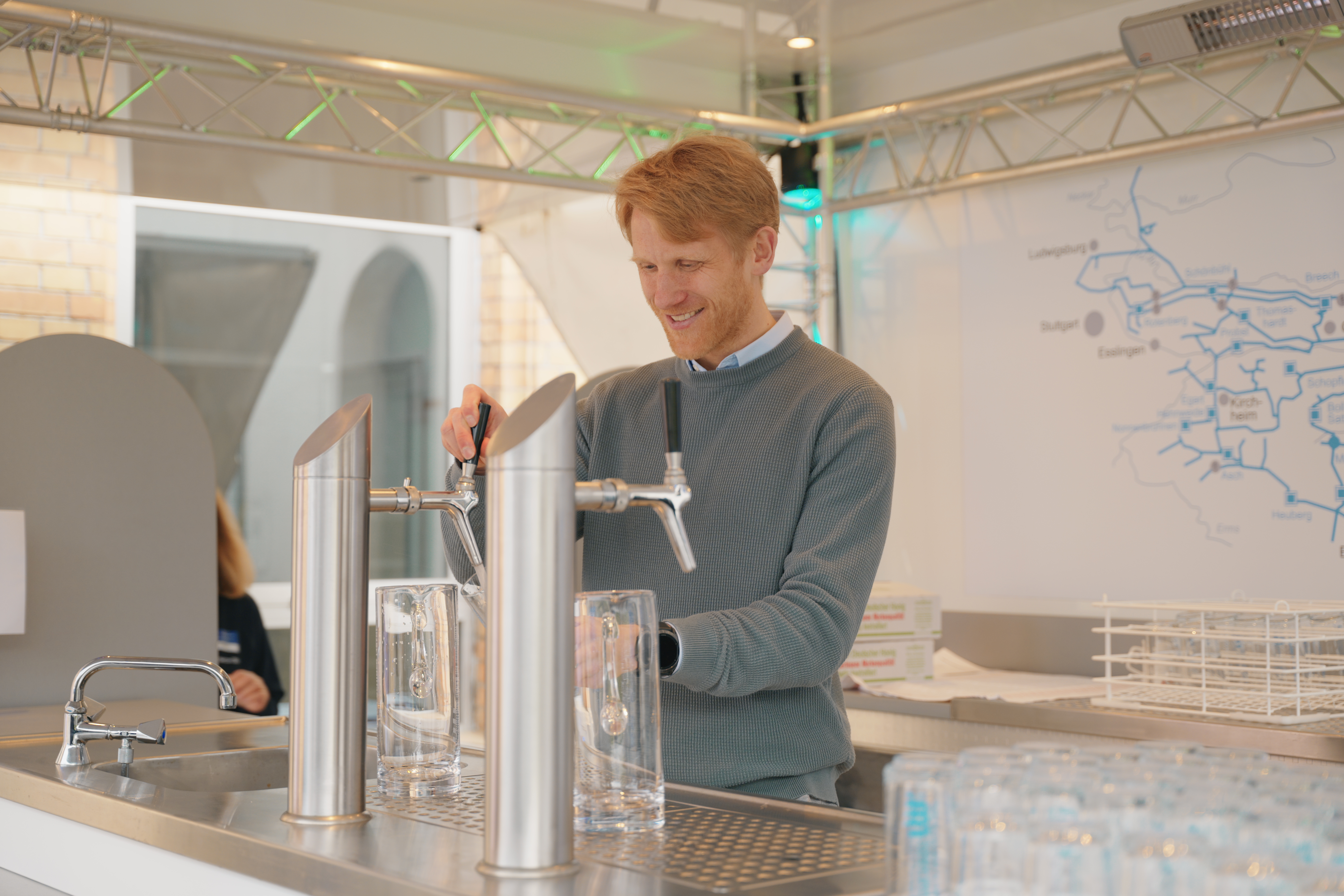 Mann im Mittelpunkt des Bildes mit Wasserglas.