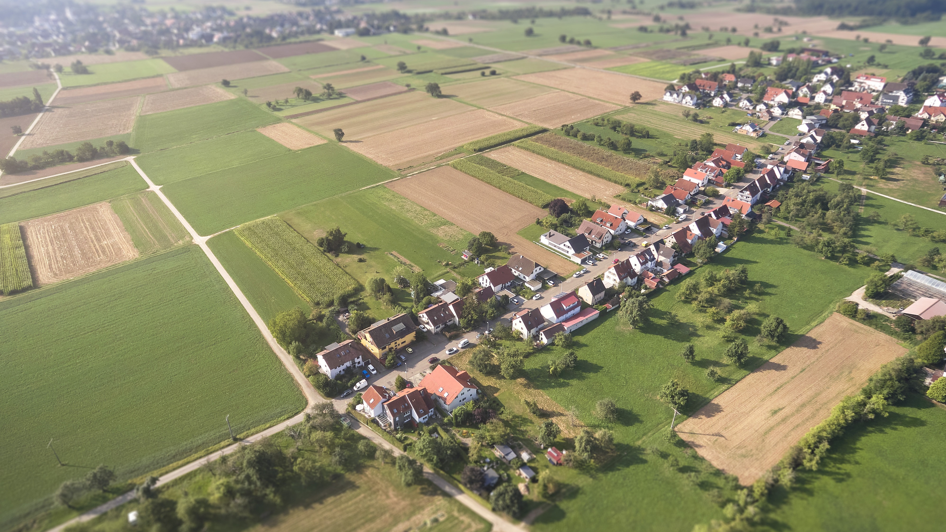 Luftbild: Dorf mit Feldern.