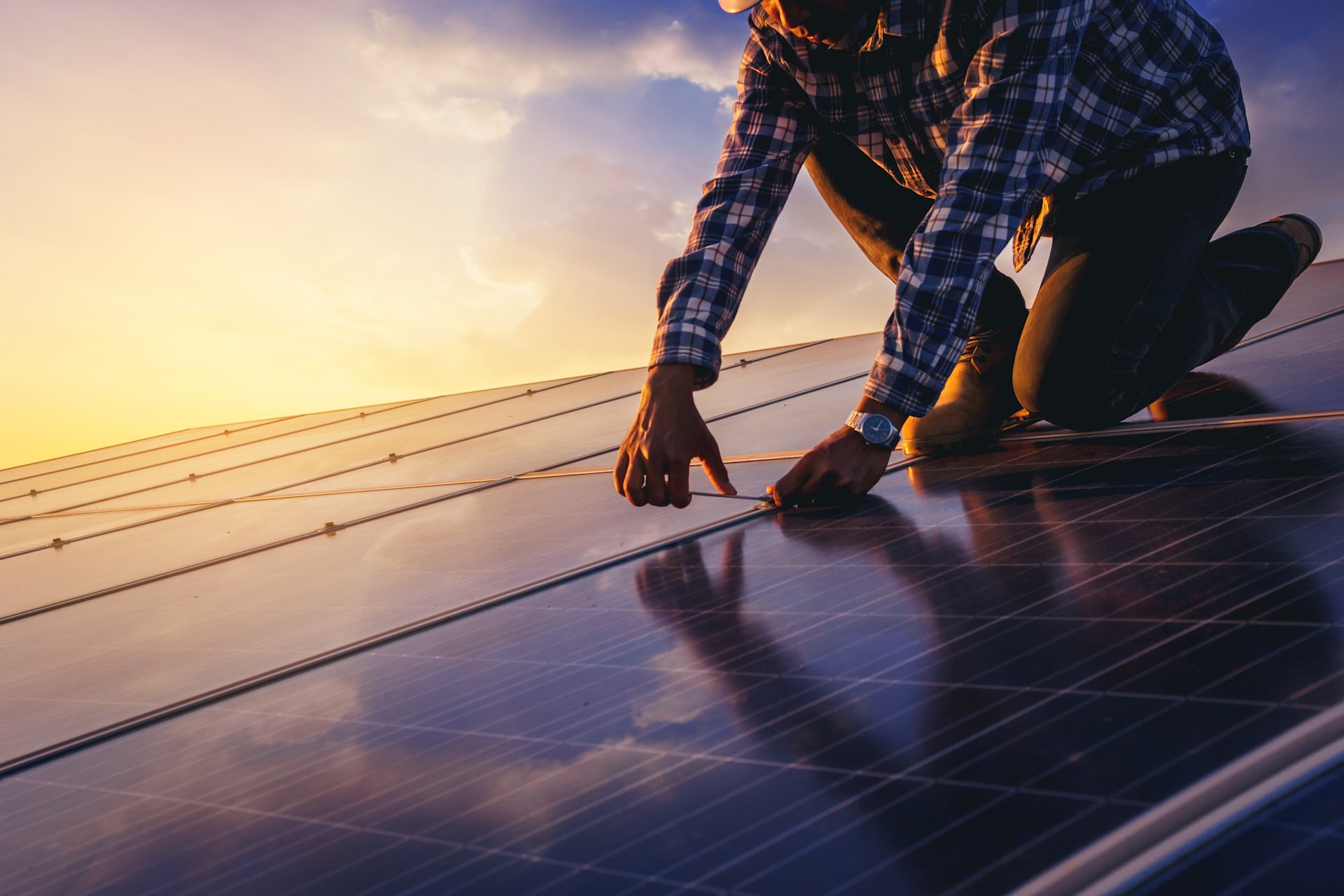Techniker repariert Solaranlage bei Sonnenuntergang.