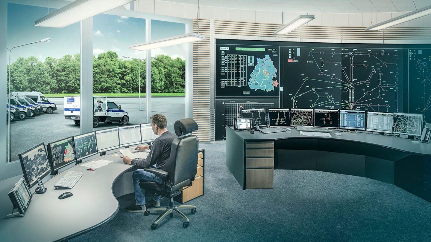 Moderne Leitstelle mit vielen Monitoren und Blick auf einen Parkplatz.
