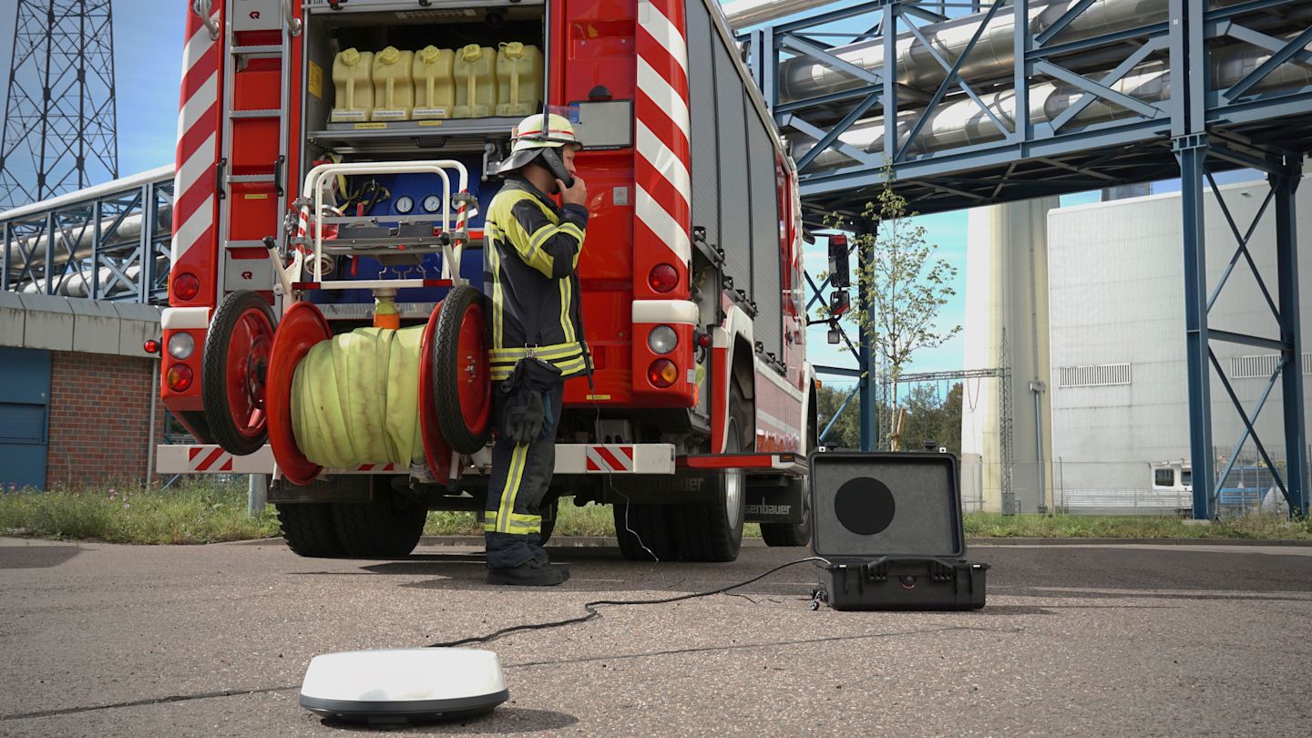 Feuerwehrmann mit Satelliten-Kommunikation am Einsatzwagen.