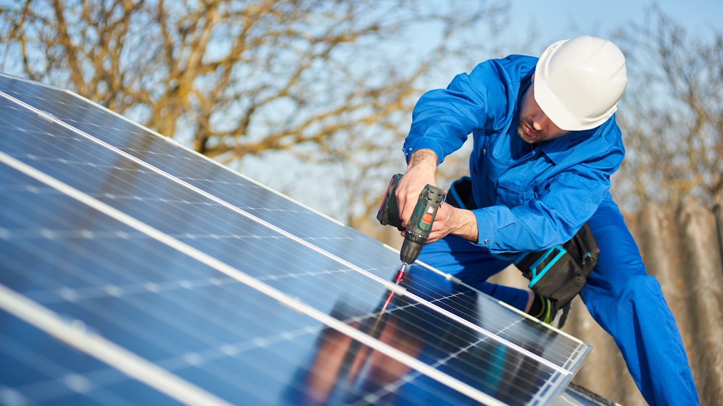 Monteur montiert Solarpanel.