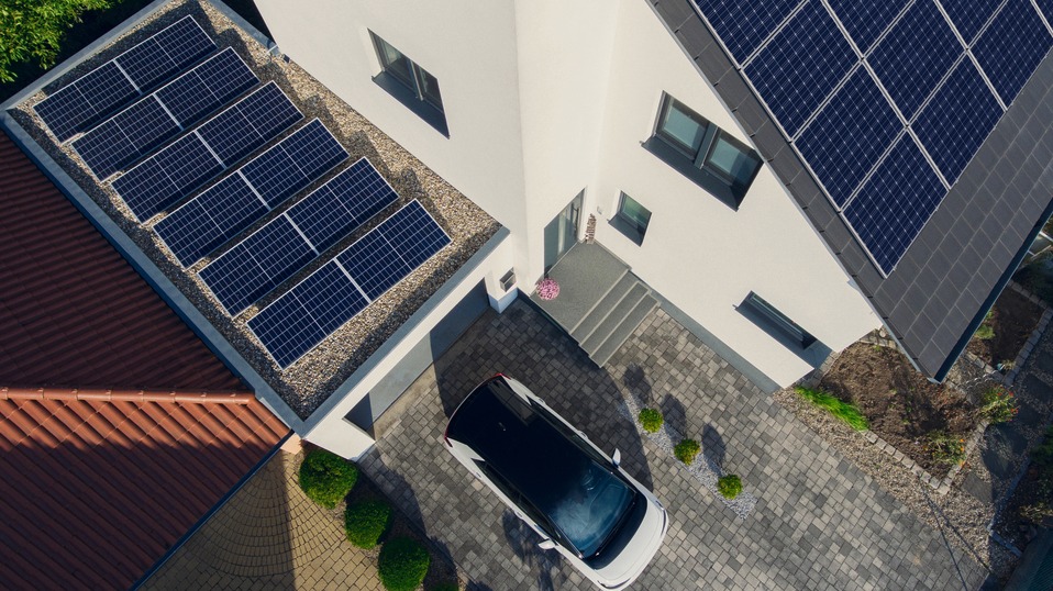 Haus mit Solaranlage und E-Auto.