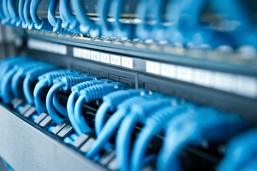 Blaue Netzwerkkabel in einem Patchfeld einer LAN-Infrastruktur