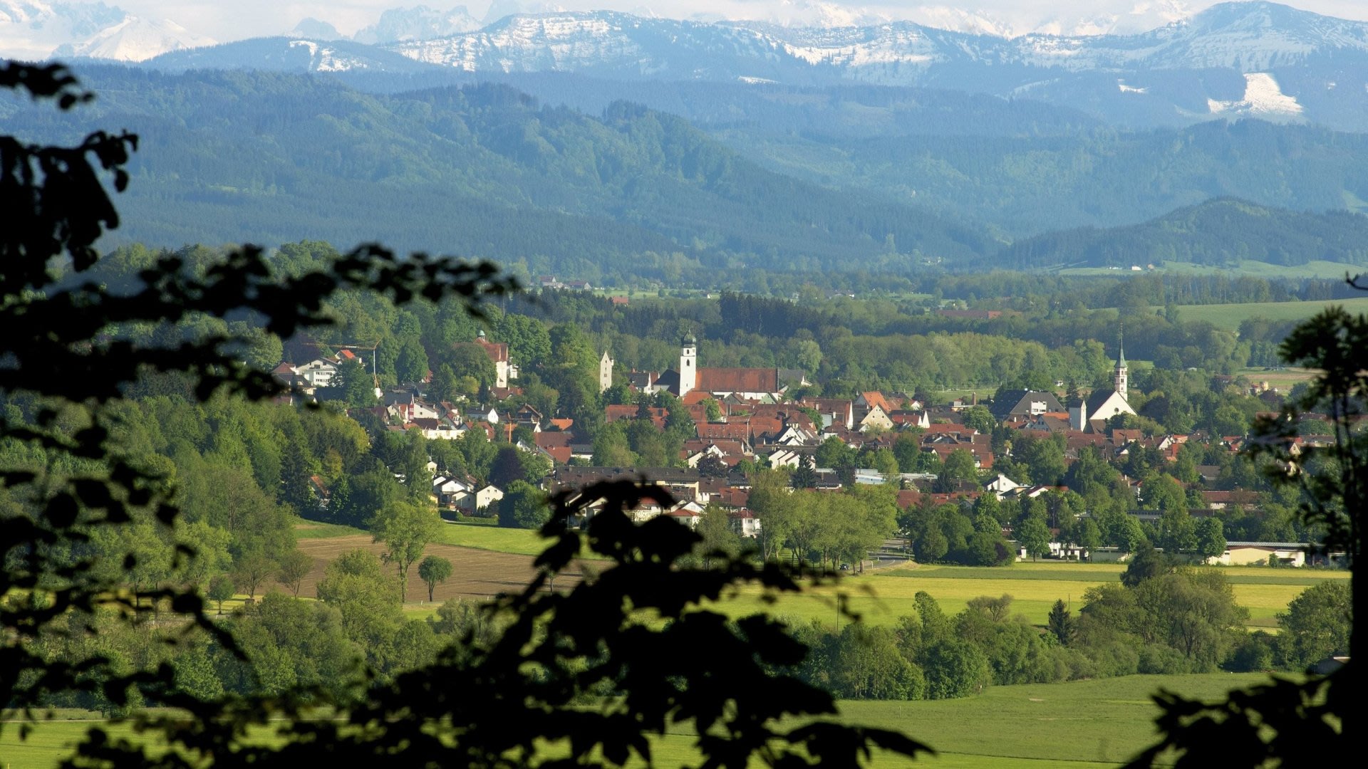 Dorflandschaft mit Bergen im Hintergrund.