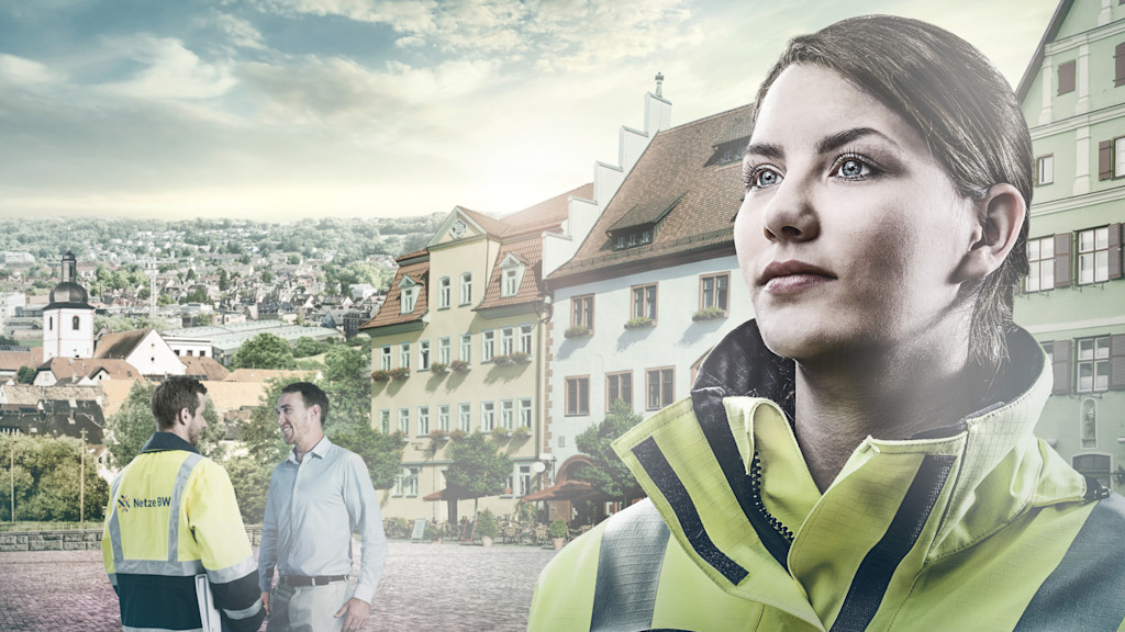 Eine Frau in Arbeitskleidung, zwei Männer und eine Stadt im Hintergrund.