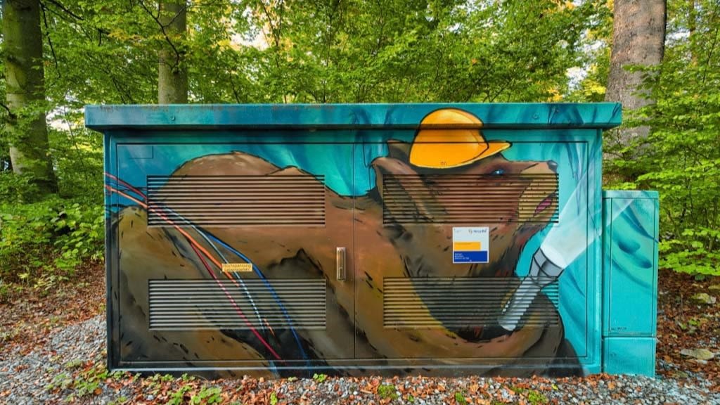 Graffiti: Bär mit Helm und Taschenlampe an Trafostation.