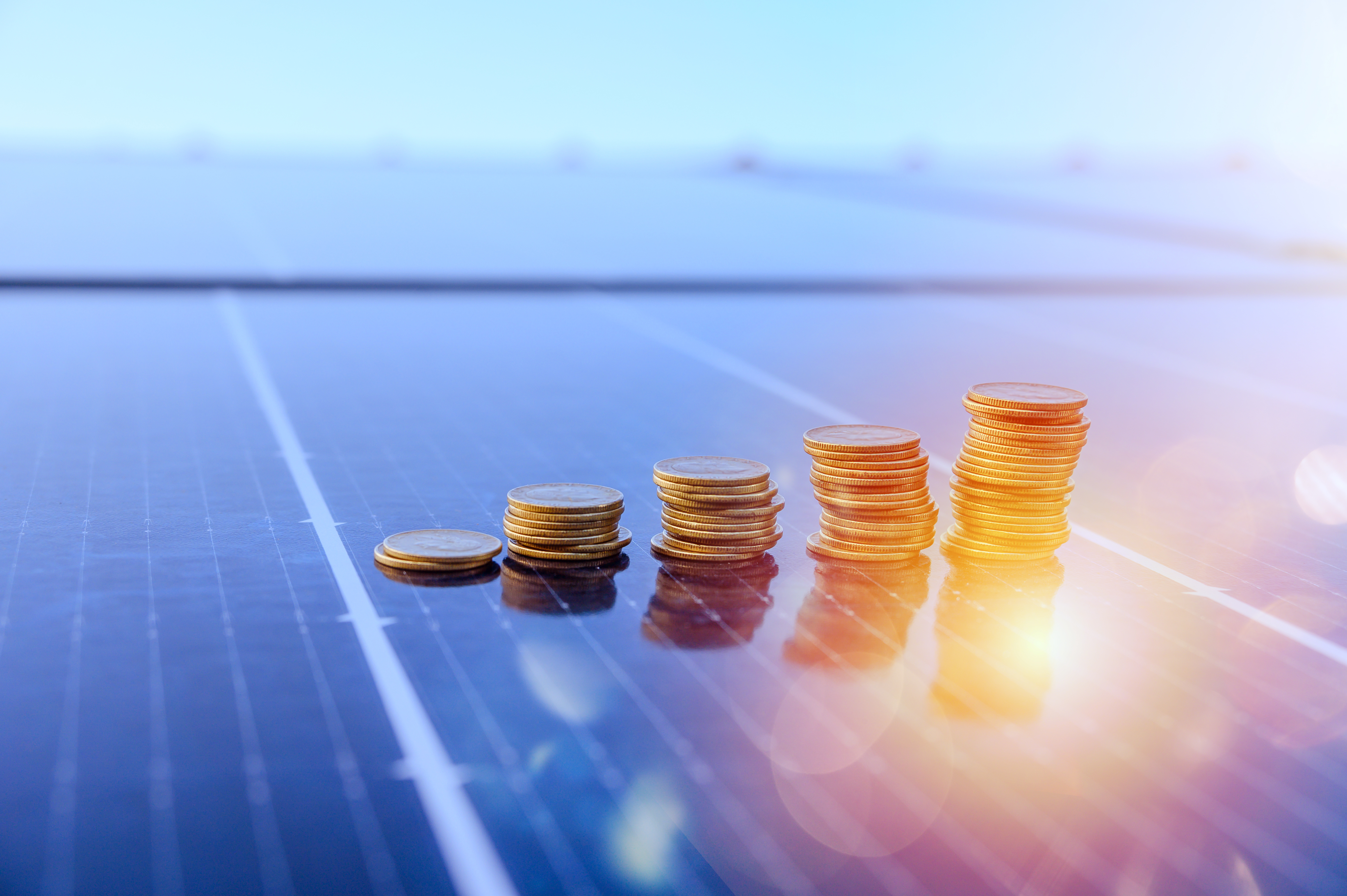 Mehrere Münzstapel auf Solarpanel.