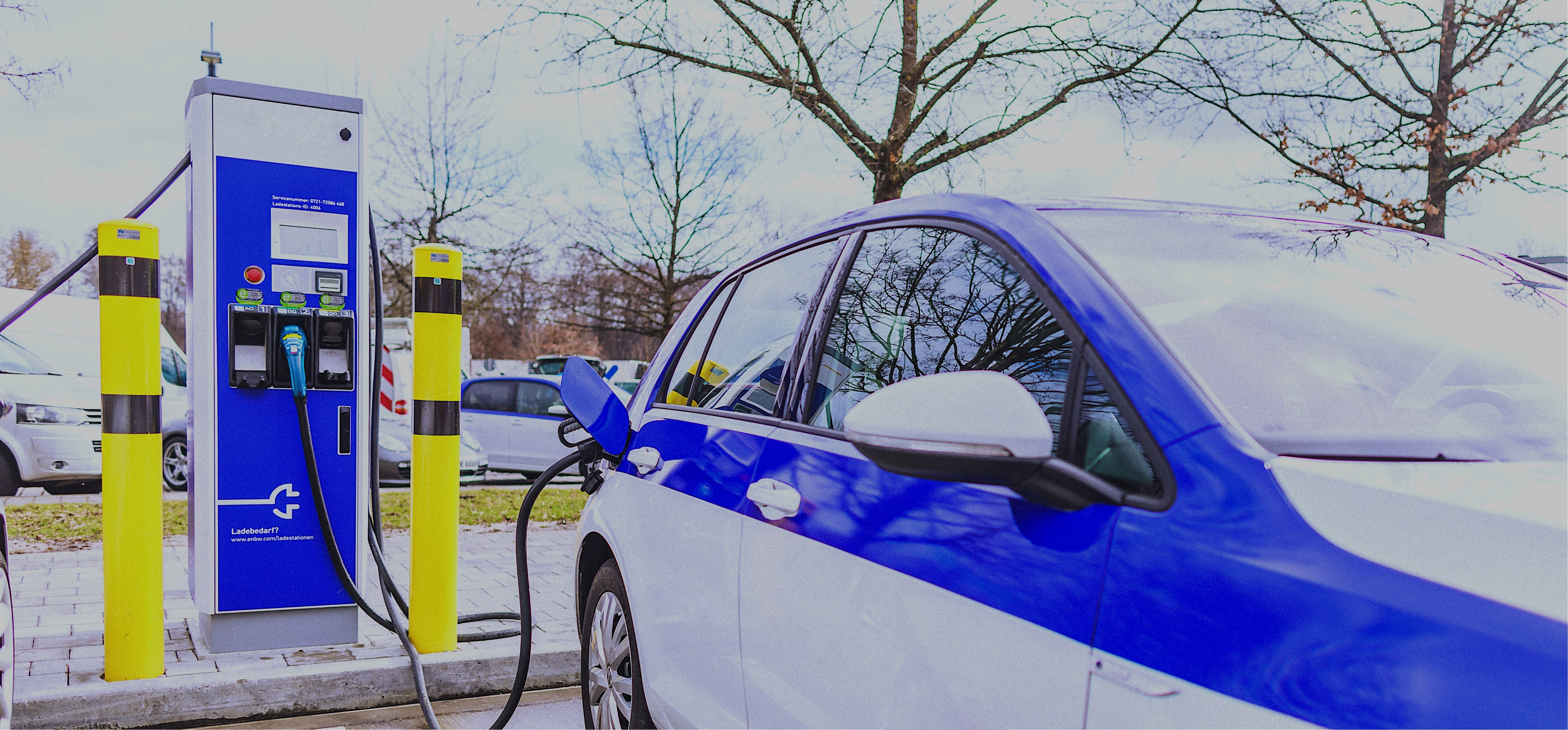 Blau-weißes Elektroauto am Ladepunkt.