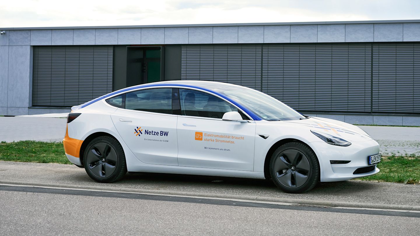 Weißes Tesla Model 3 mit Netze-BW-Werbung.