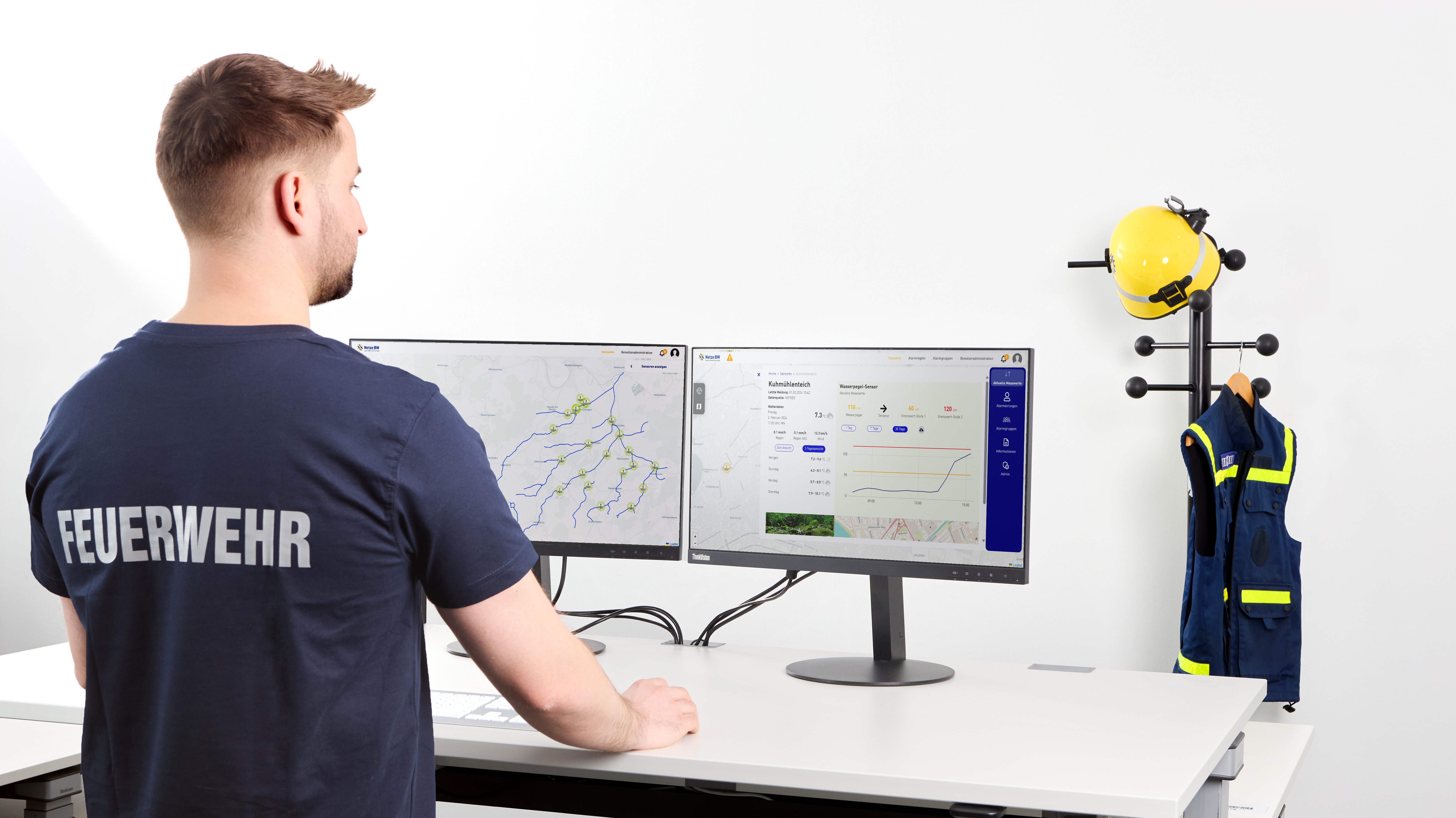 Feuerwehrmann analysiert Daten auf zwei Bildschirmen.