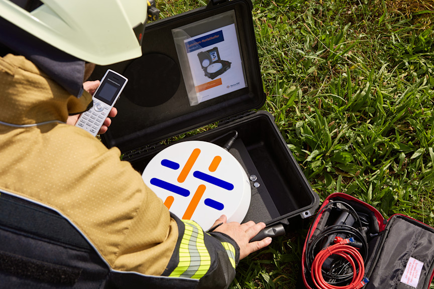 Monteur mit Satelliten-Kommunikationskoffer.