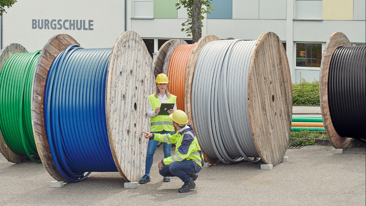 Ein Techniker und eine Technikerin prüfen Kabelrollen.