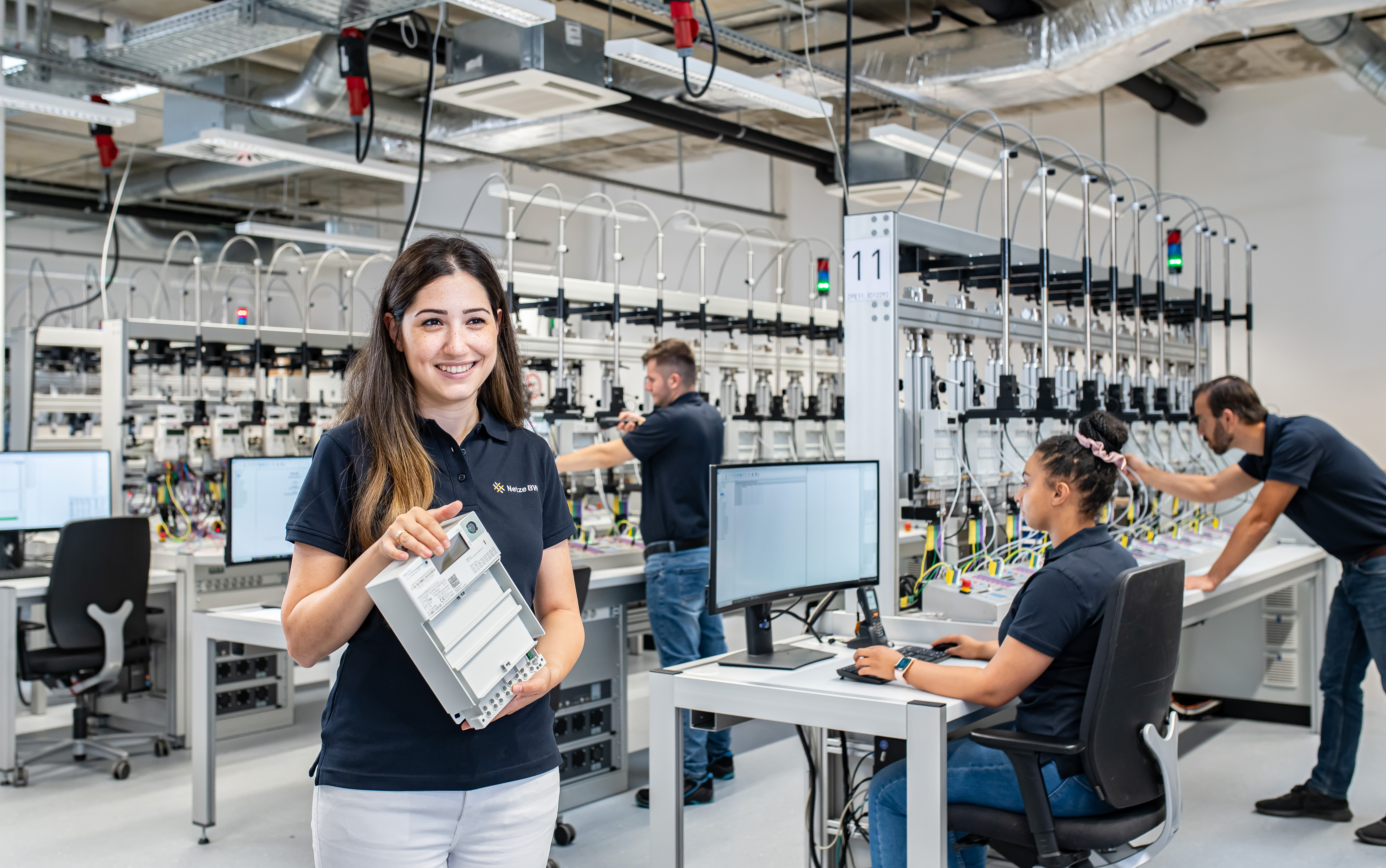 Mitarbeiterin mit digitalem Zähler im Technikraum.