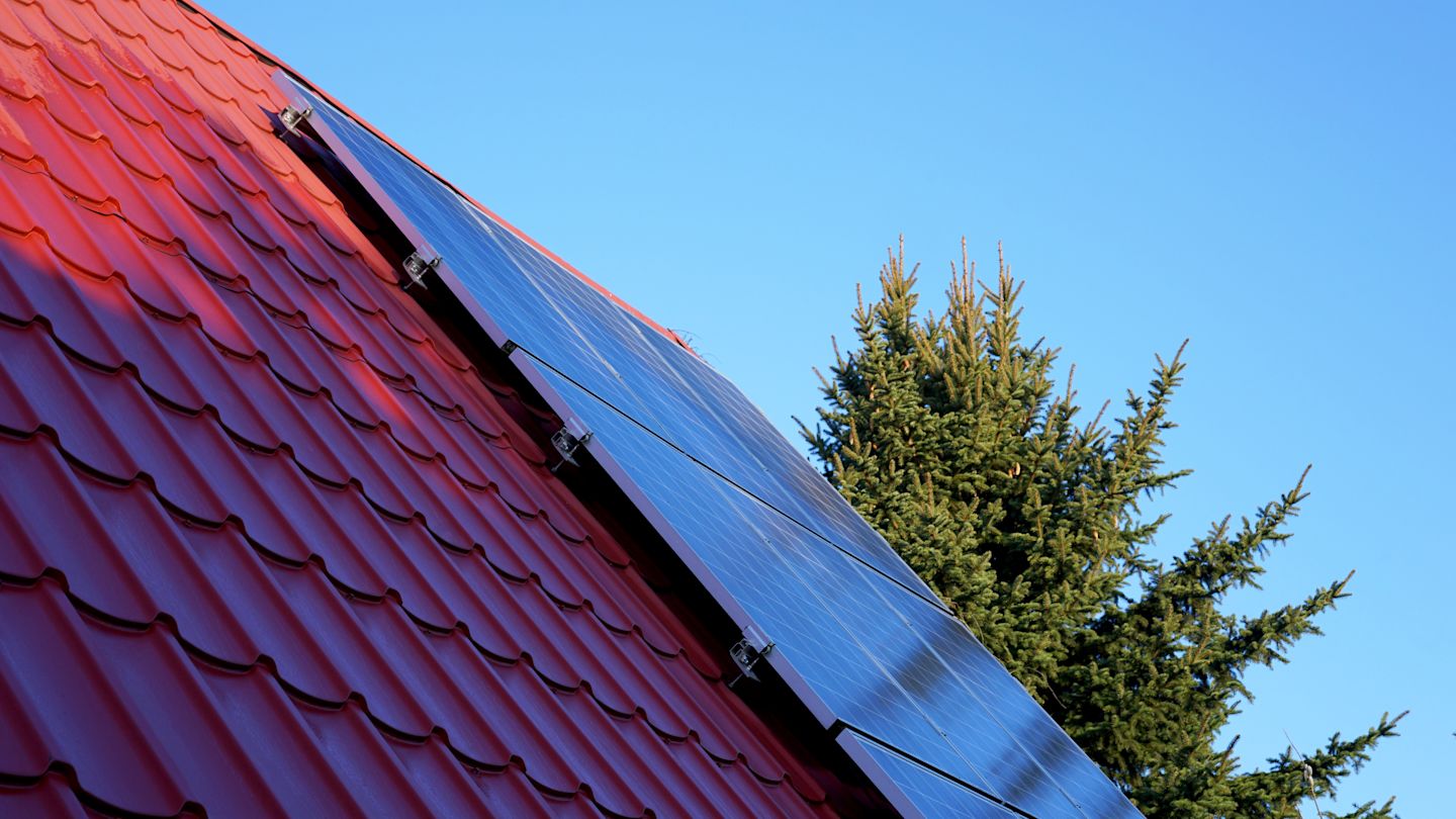 Solarkollektoren auf rotem Dach.