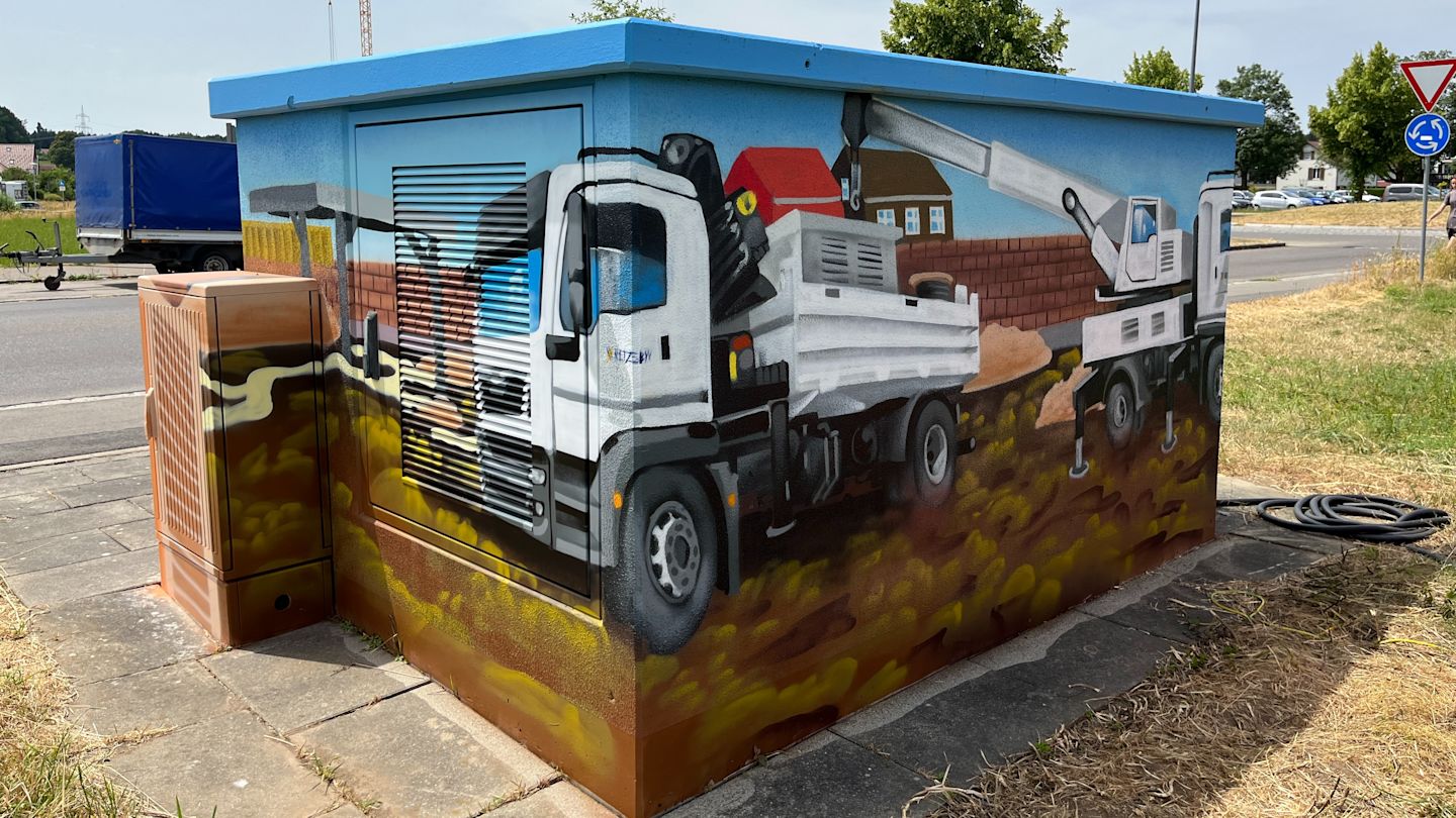Graffiti-Kunst: Baufahrzeuge an Trafostation.