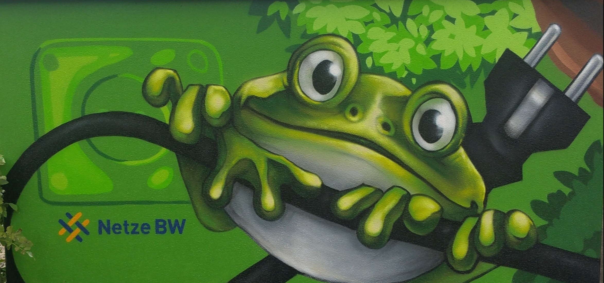 Graffiti-Kunst: Frosch an Stromkabel, Netze BW Logo.