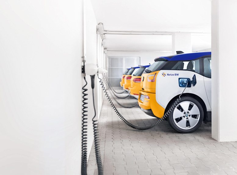 E-Autos stehen an Ladestationen in einer Garage.