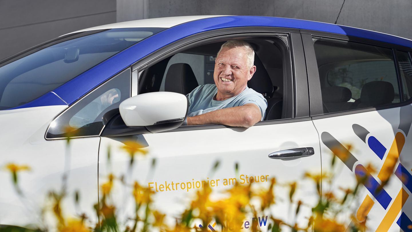E-Pionier Berthold Grauer weißem Elektroauto der Netze BW GmbH.