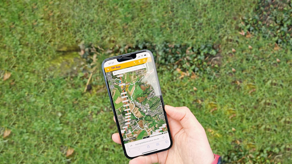 Smartphone mit TIP-App: Karte von Trassen und Vegetation.