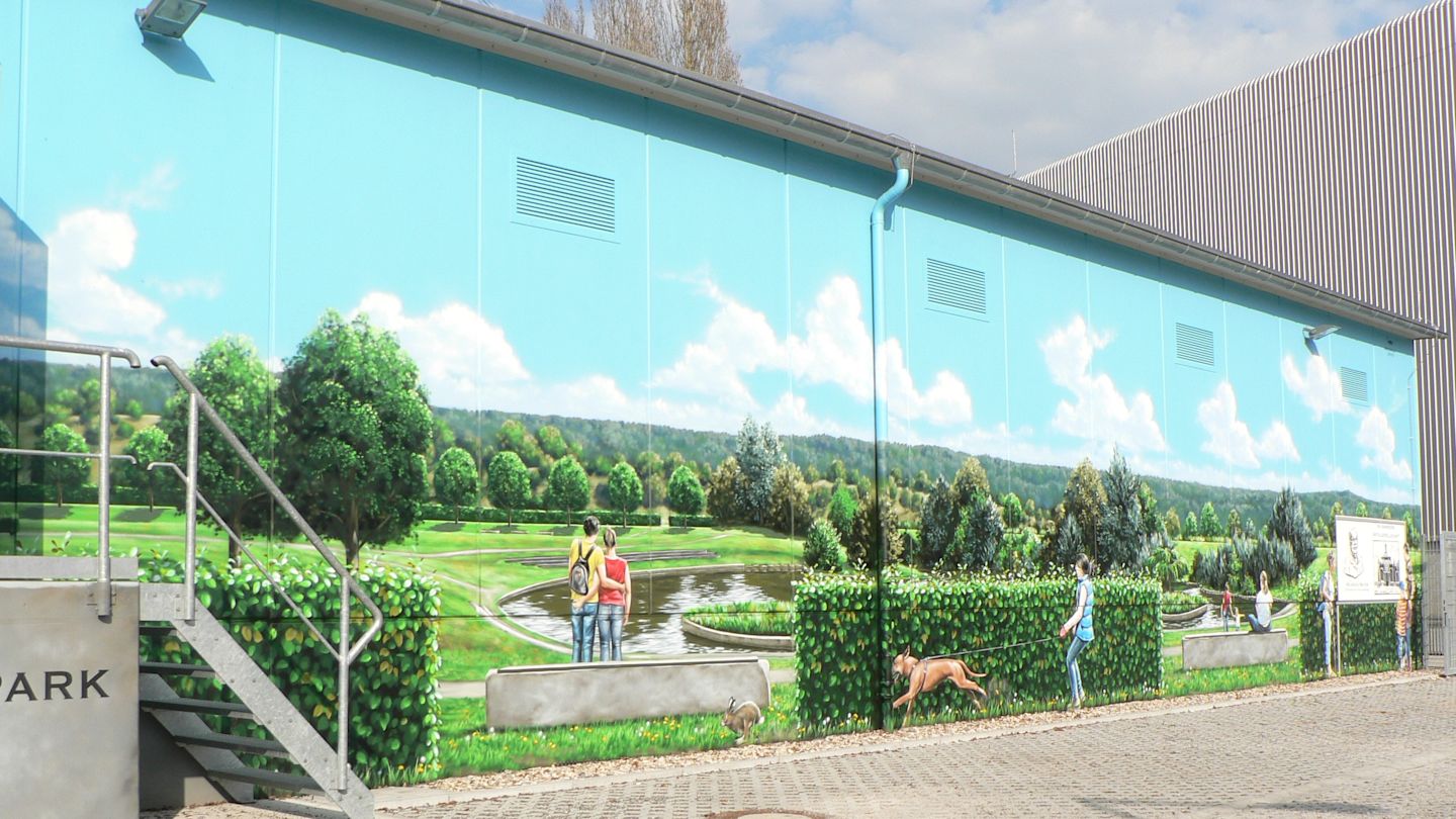 Wandgemälde auf Umspannwerk: Parklandschaft mit Menschen und Hund.