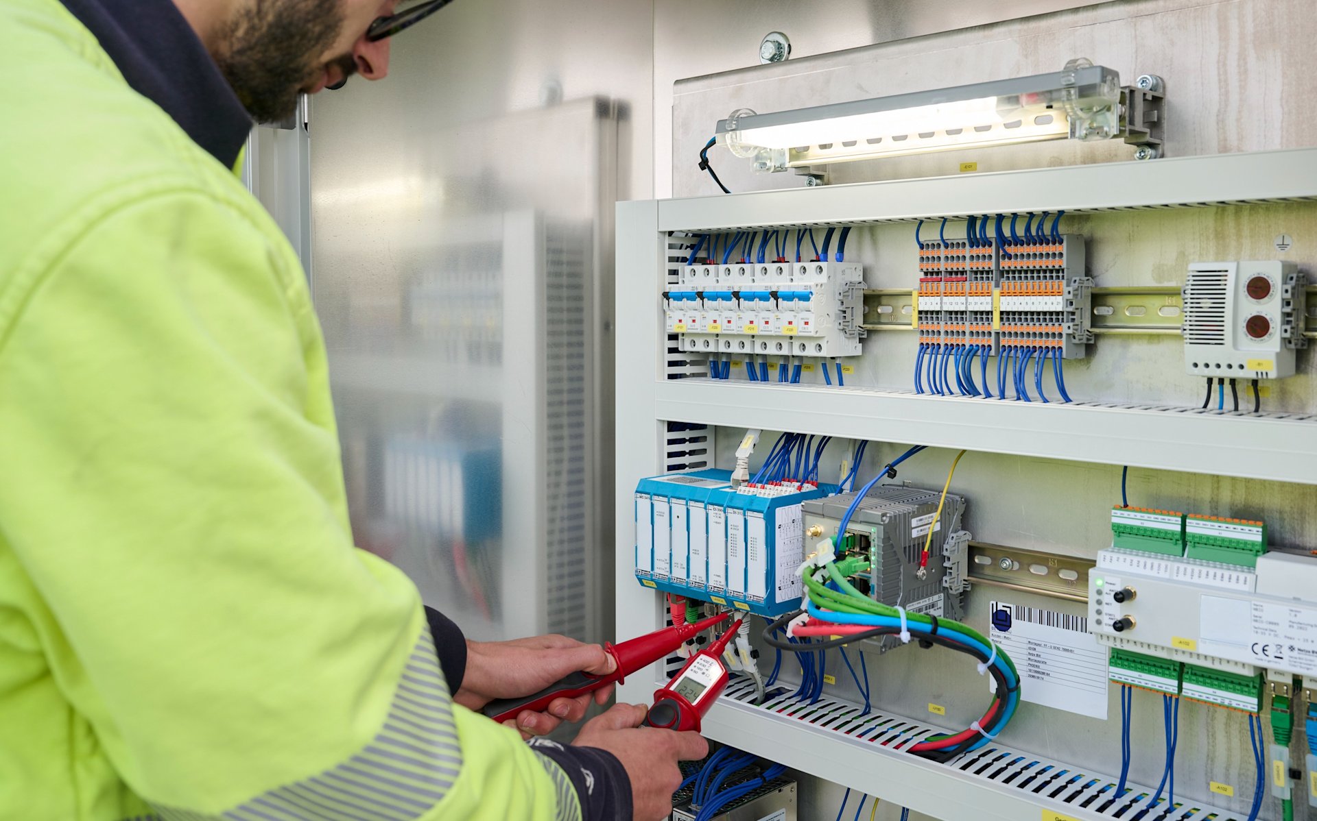 Mann der an einem Schaltkasten arbeitet.