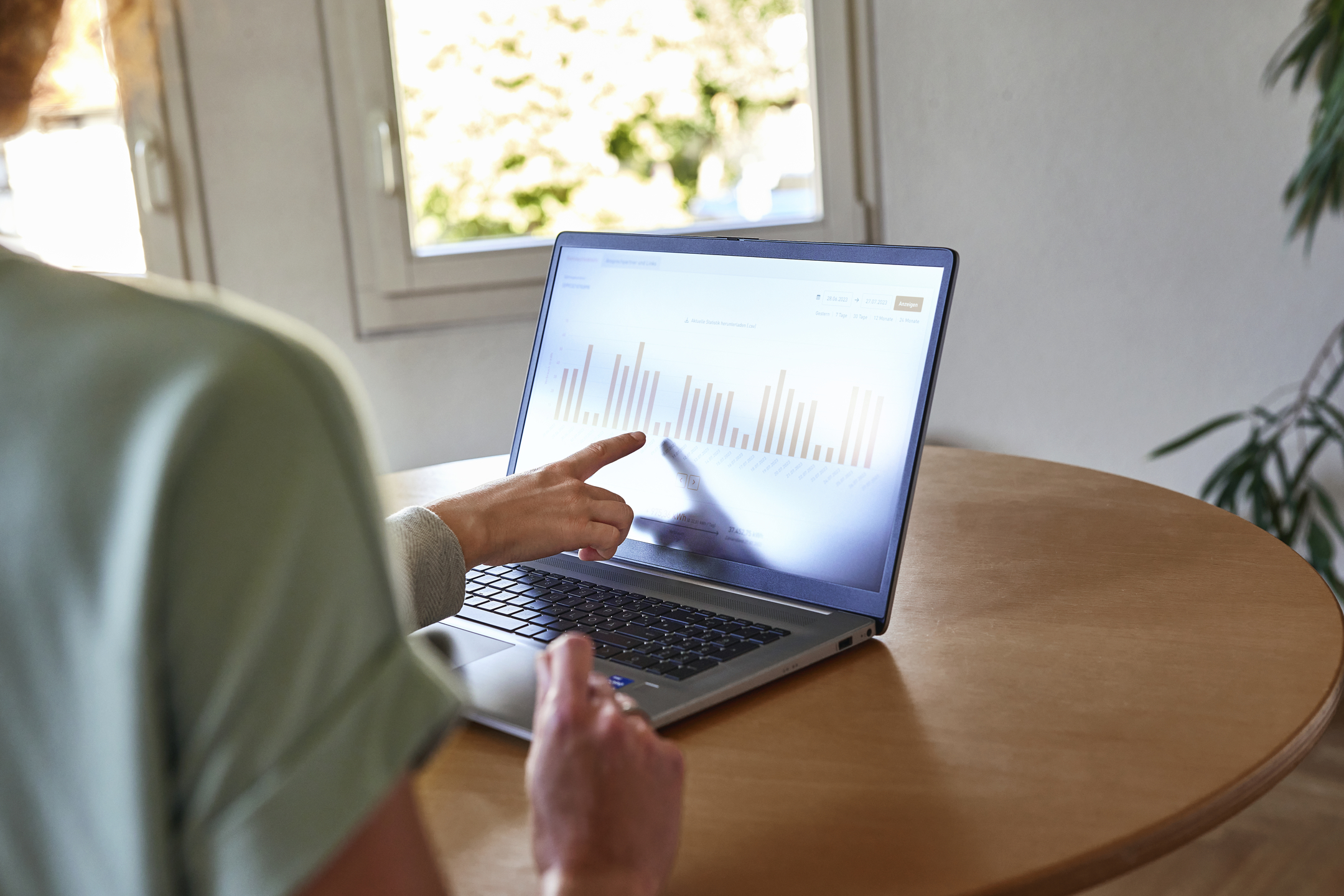 Zwei Personen besprechen ein Diagramm an einem Laptop.