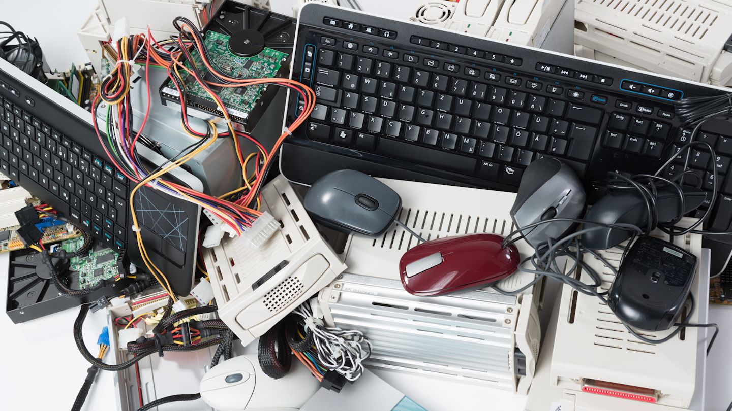 Computerzubehör liegt unordentlich auf einem Tisch verteilt.