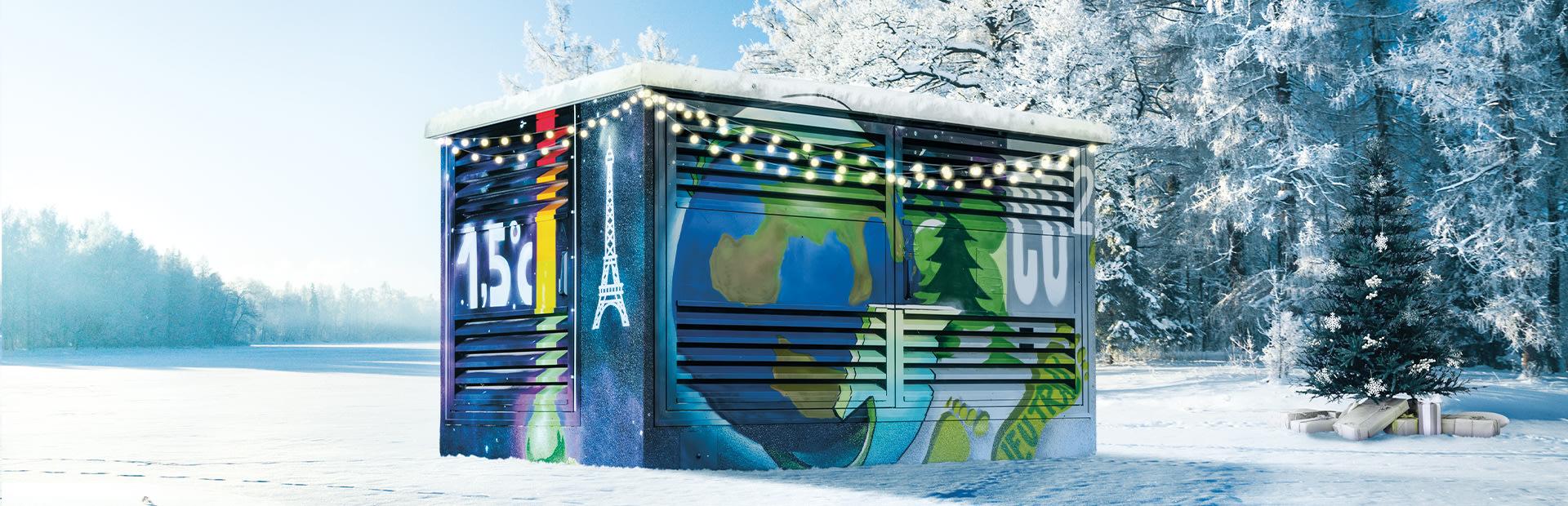 Graffiti: Stromverteilerkasten im Schnee mit weihnachtlicher Beleuchtung.