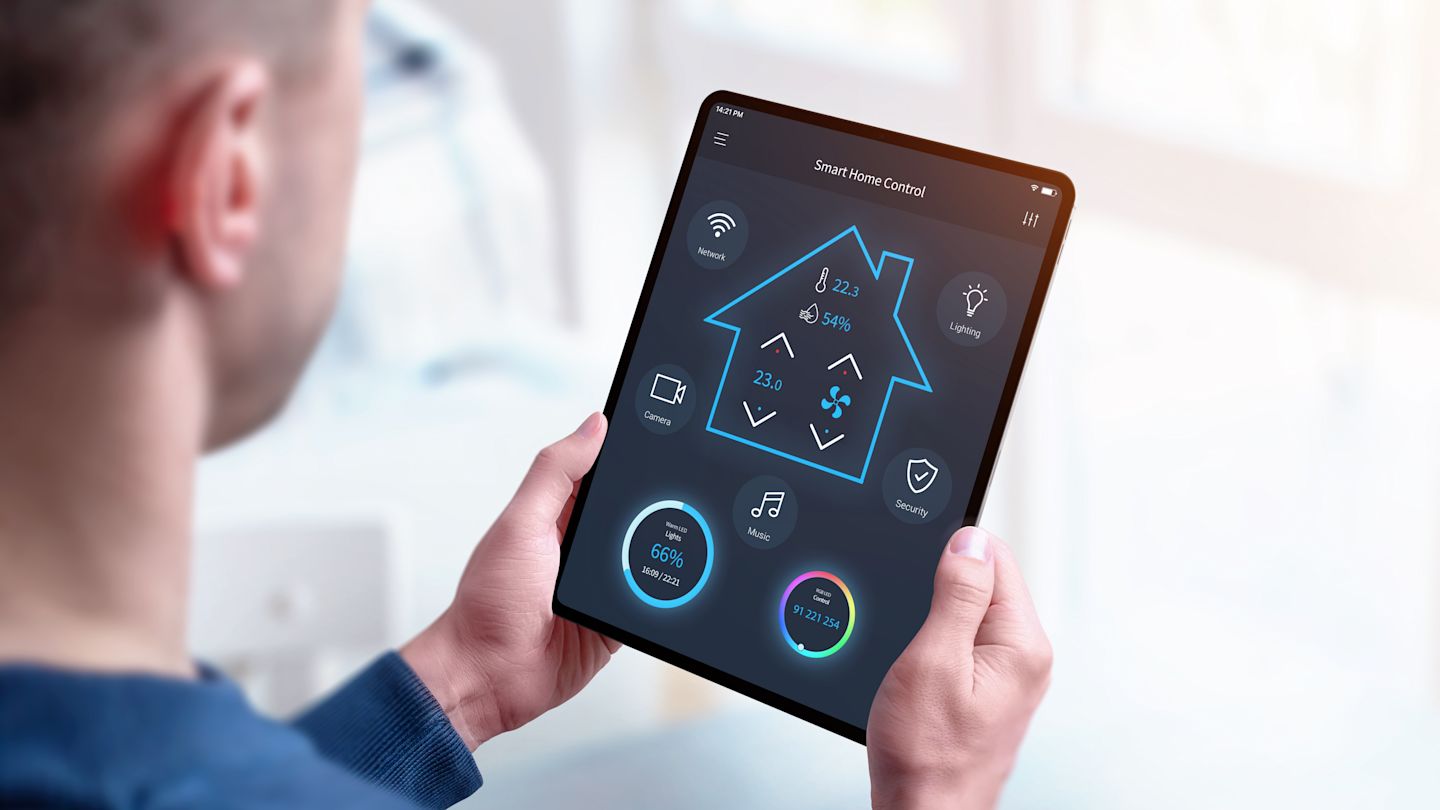 Man hält Tablet in den Händen auf dem "Smart Home Control" zu sehen ist.