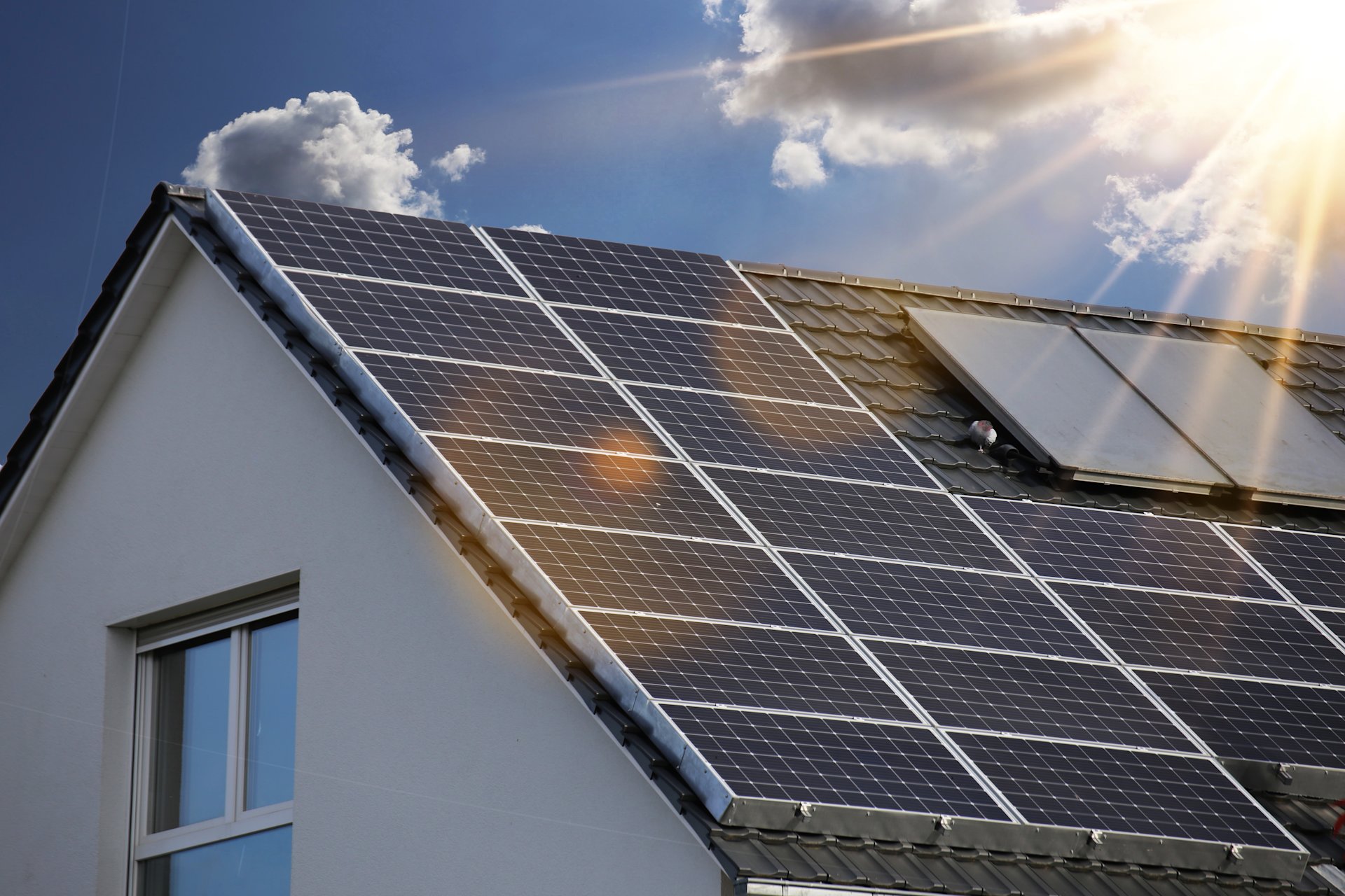 Hausdach mit Solarmodulen bei Sonnenschein.
