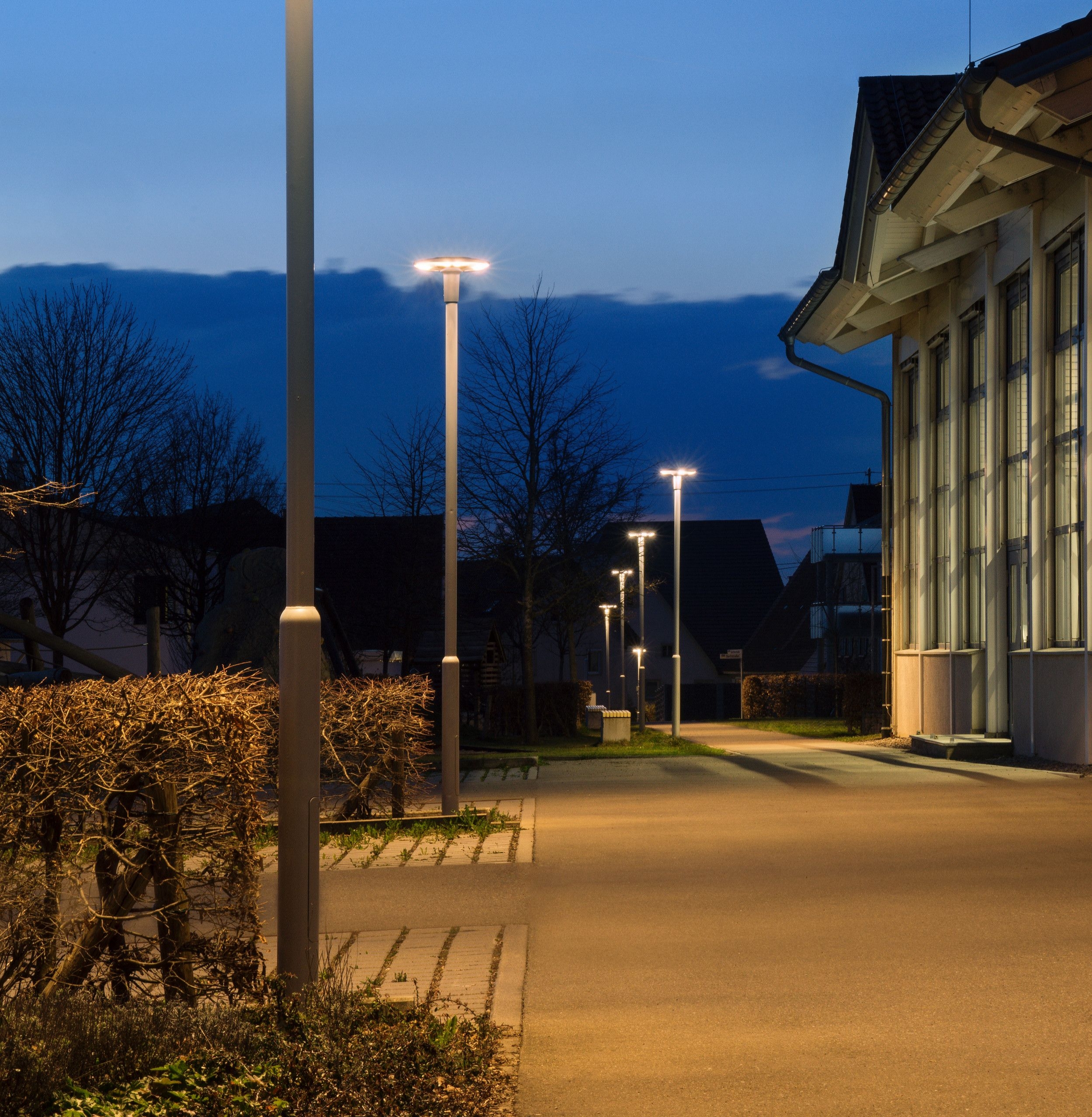 Beleuchteter Parkplatz mit LED-Laternen am Abend.