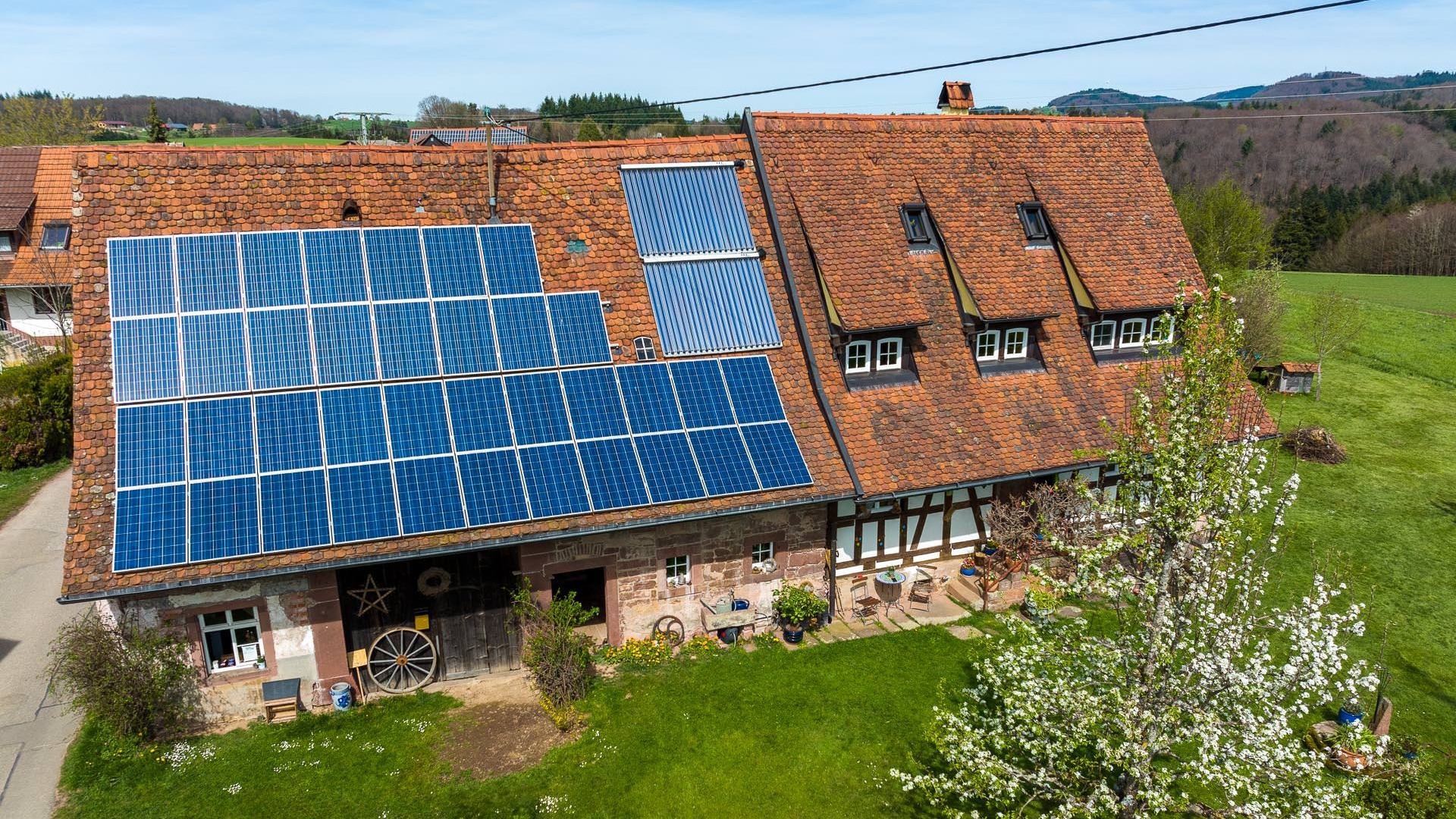 Älterer freistehender Hof mit PV-Anlage auf dem Dach.