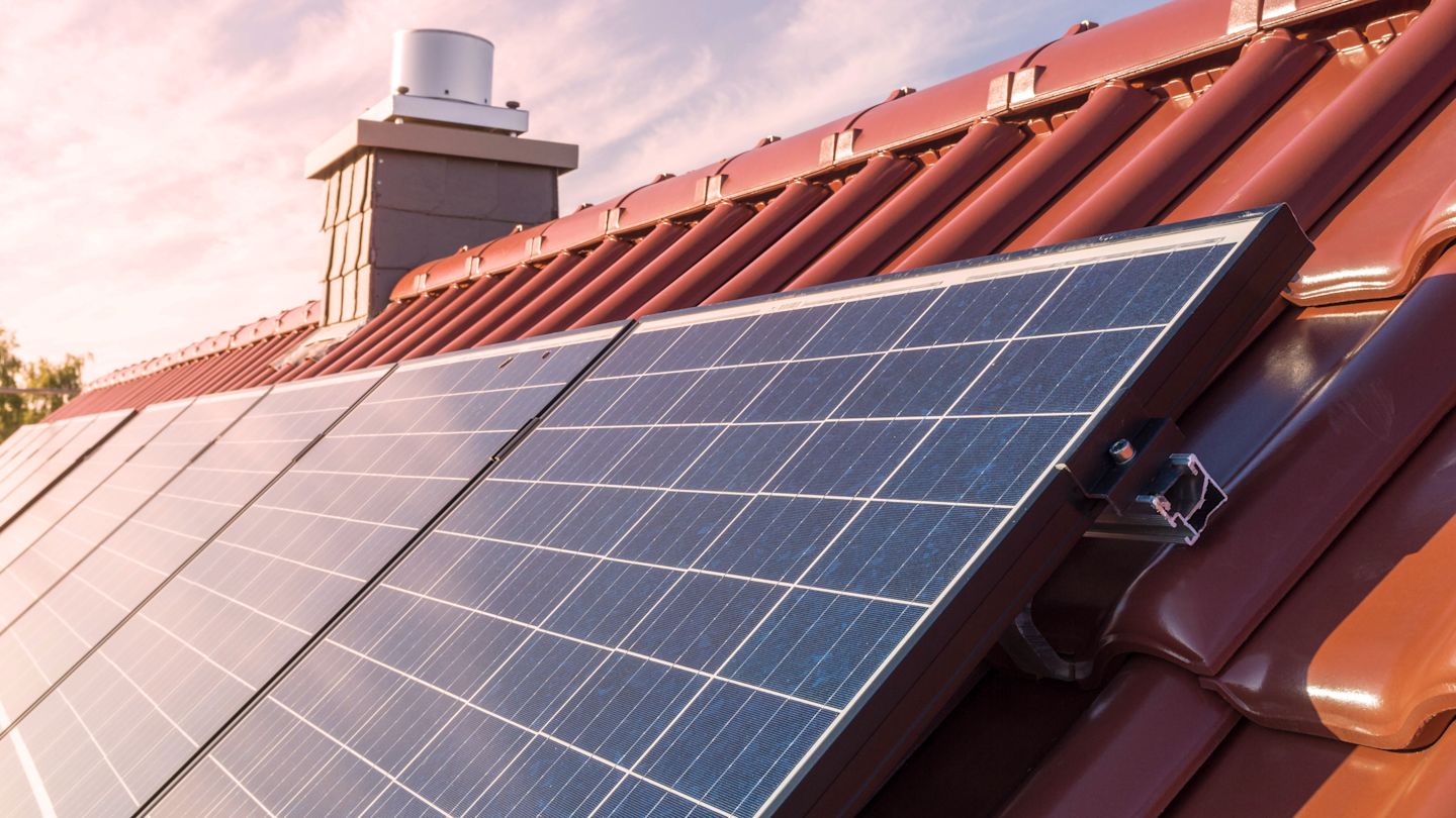 Solarmodule auf einem roten Dach.